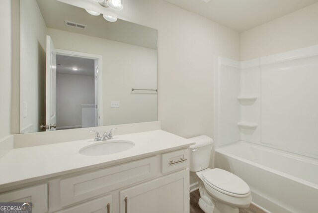 full bathroom featuring toilet,  shower combination, hardwood / wood-style flooring, and vanity