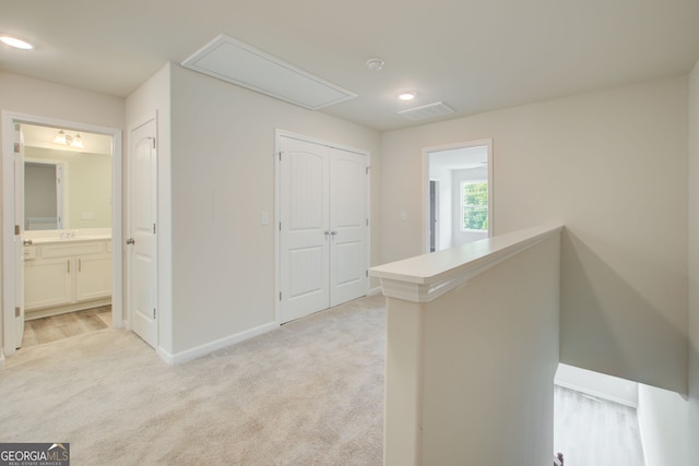 corridor featuring light colored carpet