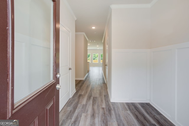 hall with light wood-type flooring and crown molding