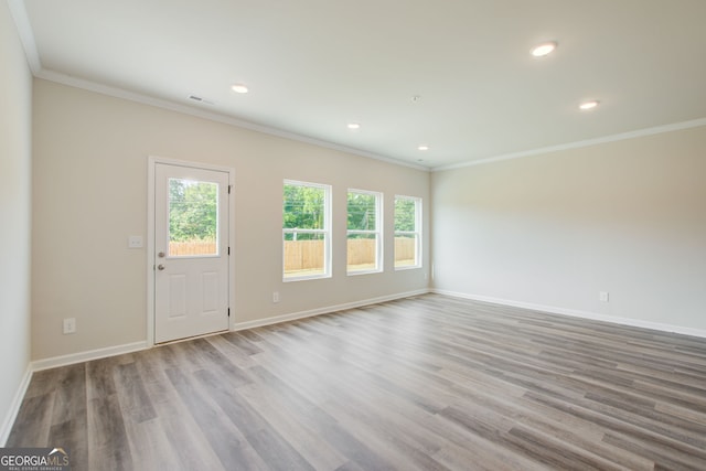 unfurnished room with light wood-type flooring and ornamental molding