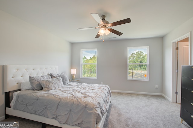 carpeted bedroom with ceiling fan and multiple windows