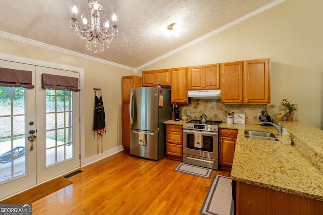 kitchen with ornamental molding, a textured ceiling, stainless steel appliances, sink, and light hardwood / wood-style floors