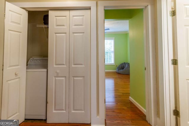 laundry room with washer / clothes dryer, crown molding, and hardwood / wood-style flooring