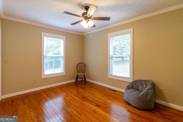 unfurnished room featuring crown molding, hardwood / wood-style floors, and a healthy amount of sunlight