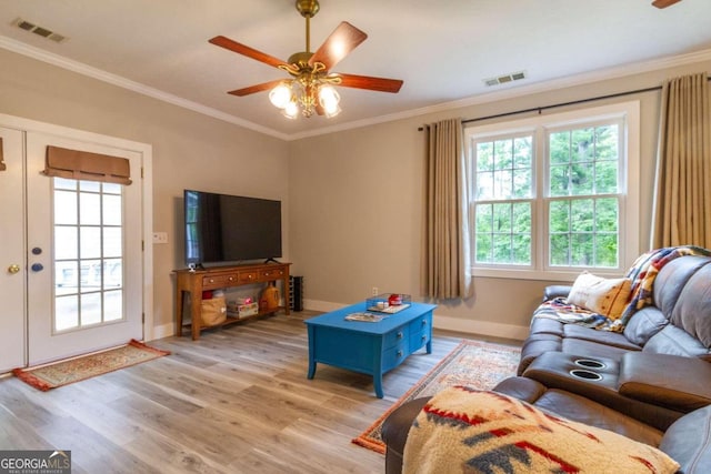 living room with ceiling fan, ornamental molding, and light wood-type flooring