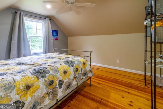 bedroom featuring ceiling fan, wood-type flooring, and lofted ceiling