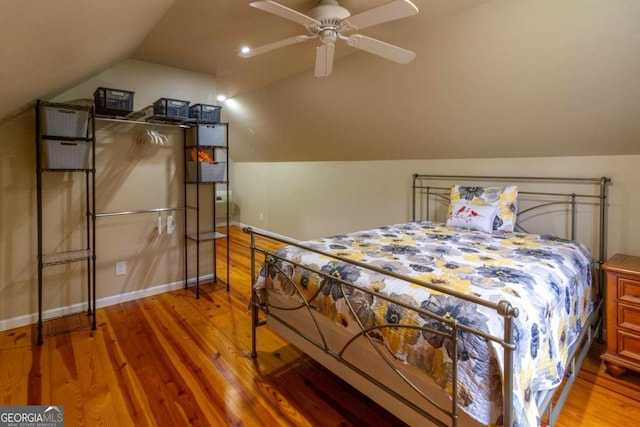 bedroom featuring ceiling fan, hardwood / wood-style floors, and vaulted ceiling