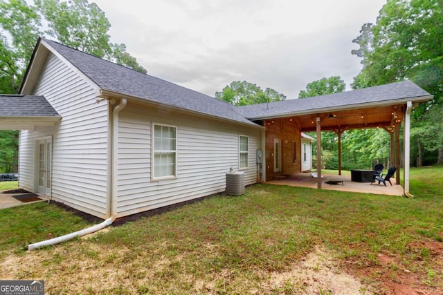 rear view of house with a yard, a patio, and central air condition unit