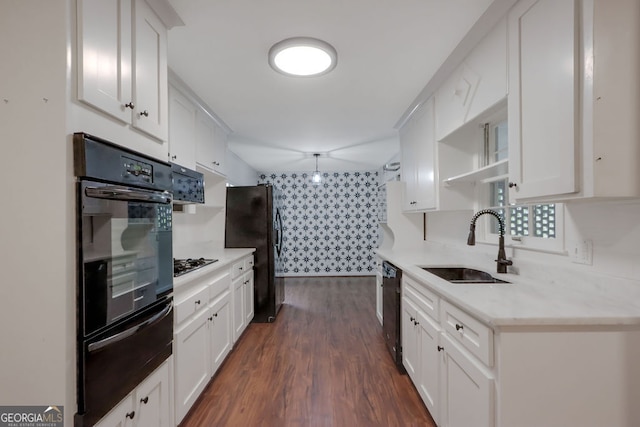 kitchen featuring light stone countertops, dark hardwood / wood-style flooring, black appliances, white cabinets, and sink