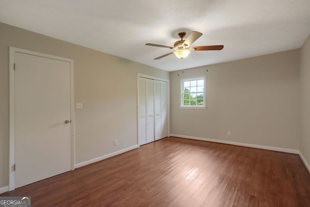 unfurnished bedroom featuring a closet, wood-type flooring, and ceiling fan