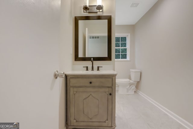 bathroom with tile floors, toilet, and vanity