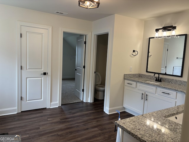 bathroom featuring visible vents, vanity, wood finished floors, toilet, and baseboards