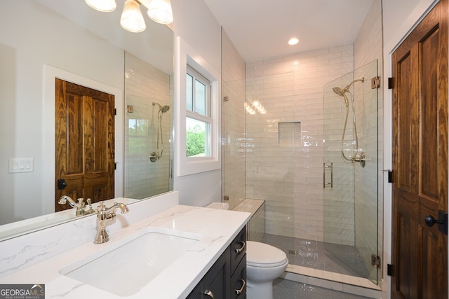 bathroom with vanity, toilet, and a shower with door