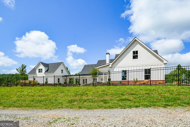 rear view of house featuring a lawn