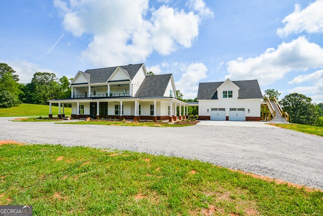 country-style home featuring a garage, a front lawn, and a porch