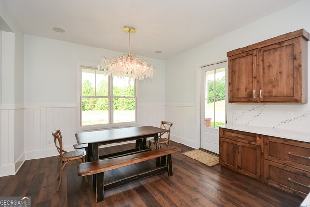 dining area featuring a healthy amount of sunlight, an inviting chandelier, and dark hardwood / wood-style flooring