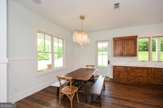 dining space with a notable chandelier and dark hardwood / wood-style flooring