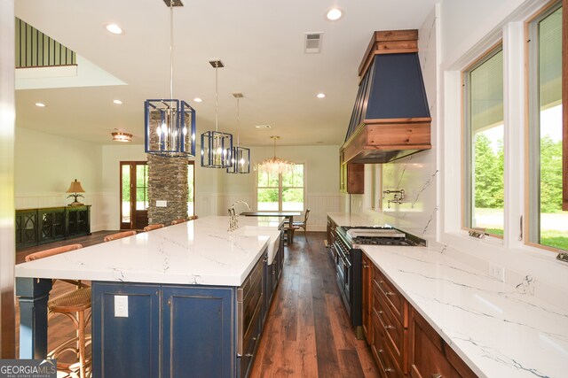 kitchen featuring double oven range, decorative light fixtures, dark wood-type flooring, custom range hood, and a large island