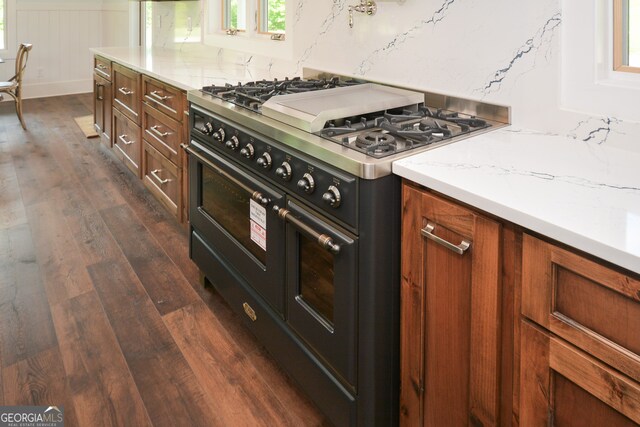 kitchen with double oven range and dark wood-type flooring