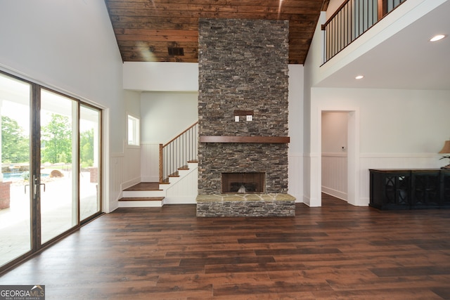 unfurnished living room with high vaulted ceiling, dark wood-type flooring, wooden ceiling, and a fireplace