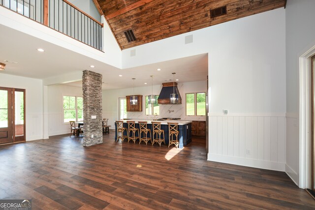 living room featuring a high ceiling, dark hardwood / wood-style floors, and a wealth of natural light