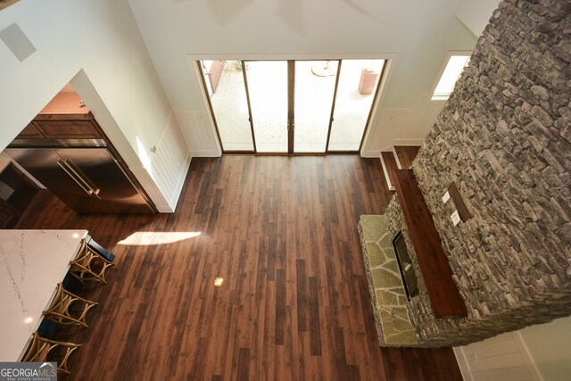 unfurnished living room featuring a high ceiling and dark wood-type flooring