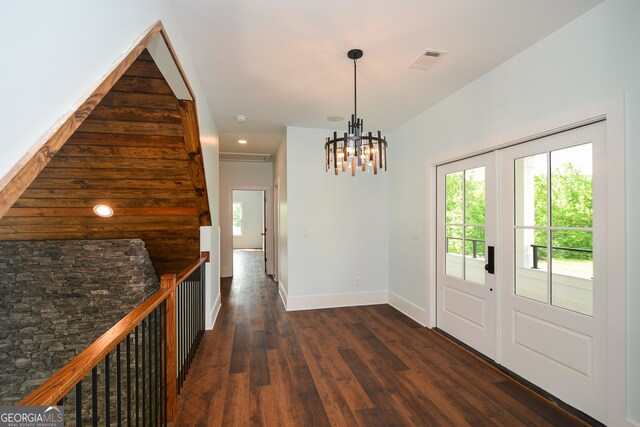 entrance foyer with an inviting chandelier and dark hardwood / wood-style flooring