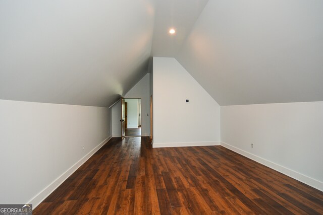 additional living space featuring dark hardwood / wood-style flooring and lofted ceiling