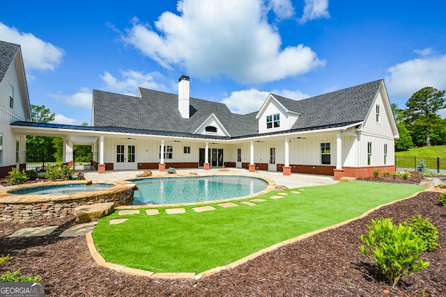 view of swimming pool featuring a patio, an in ground hot tub, and a lawn