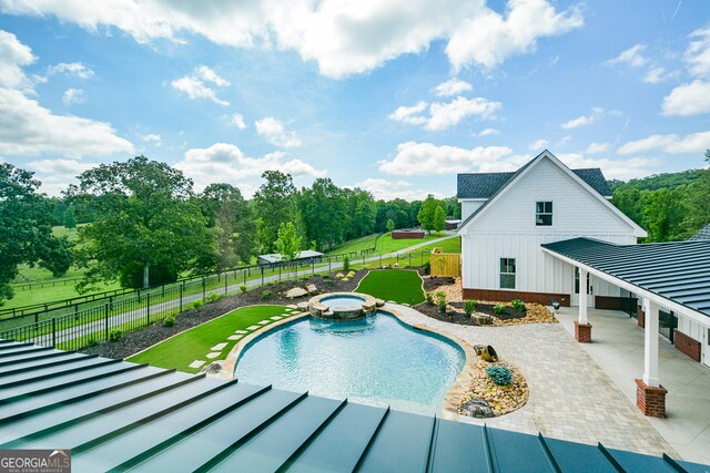 view of swimming pool with a patio and an in ground hot tub