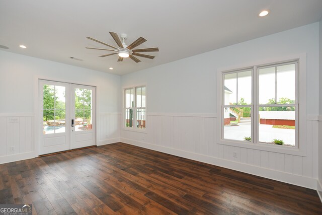 empty room featuring ceiling fan, dark hardwood / wood-style flooring, a wealth of natural light, and french doors