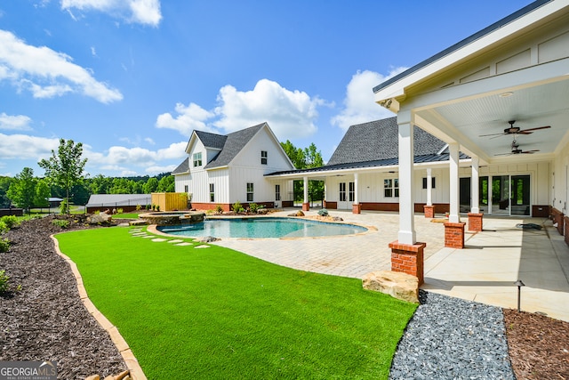 view of swimming pool with ceiling fan, a lawn, and a patio area