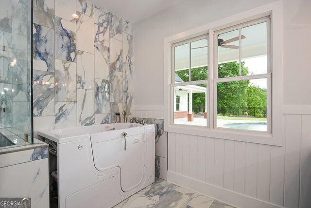 clothes washing area with ceiling fan, tile walls, and light tile flooring