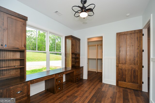 unfurnished office featuring a healthy amount of sunlight, ceiling fan, and dark hardwood / wood-style flooring