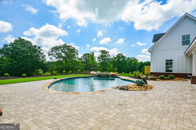 view of swimming pool with pool water feature, an in ground hot tub, and a patio