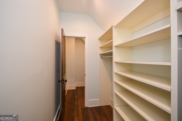 walk in closet featuring dark hardwood / wood-style floors and vaulted ceiling