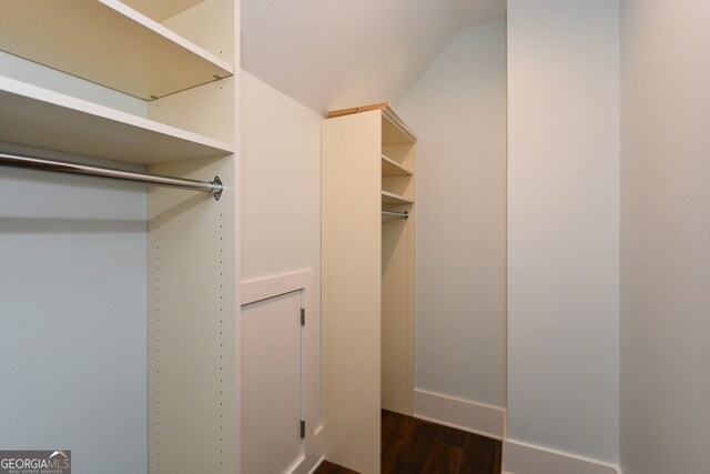 spacious closet with wood-type flooring and vaulted ceiling