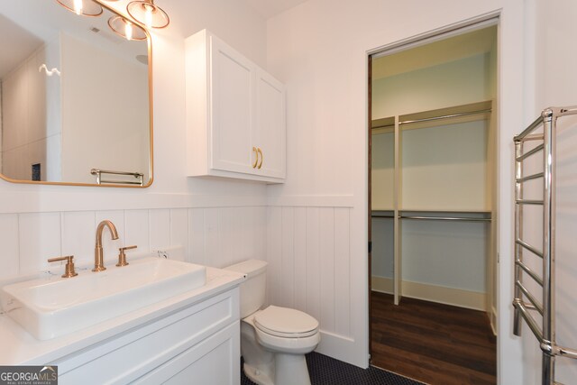 bathroom with radiator, vanity, toilet, and hardwood / wood-style floors