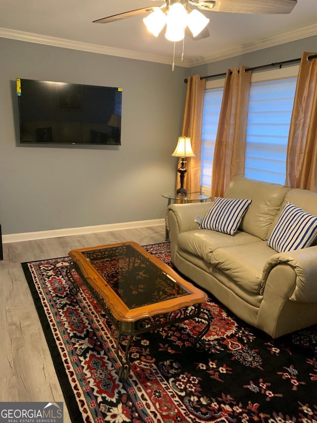 living room with hardwood / wood-style flooring, ceiling fan, and crown molding