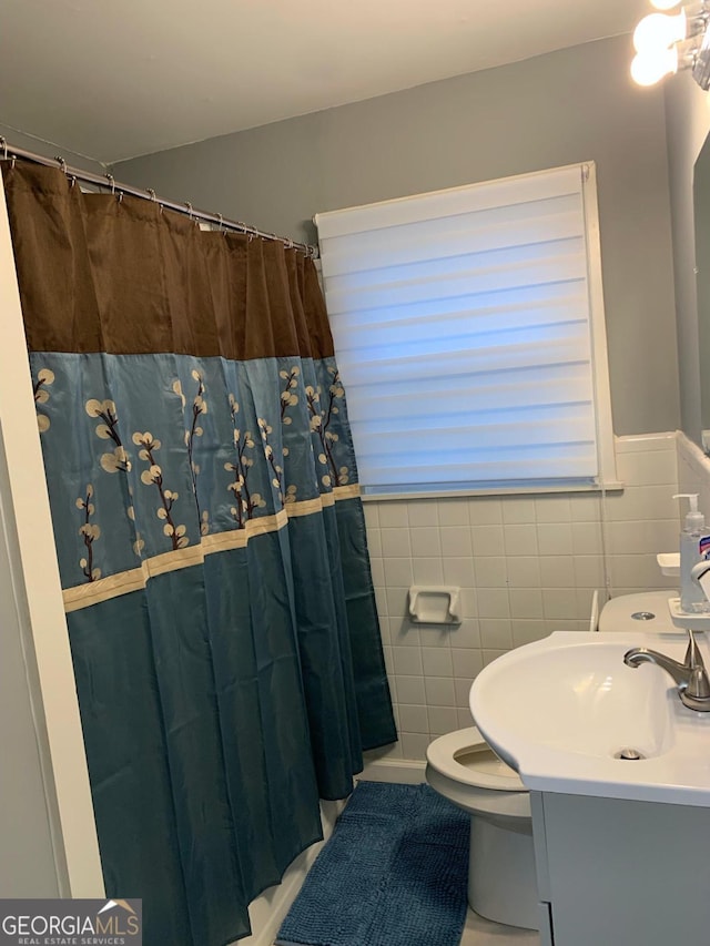 bathroom with a shower with curtain, tile patterned flooring, and tile walls