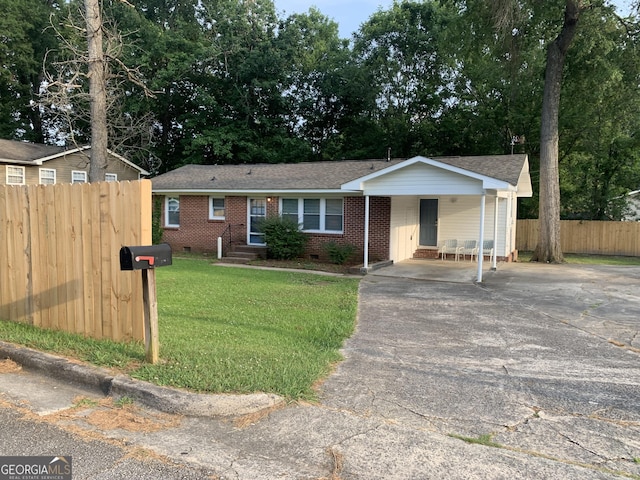 ranch-style home with a carport and a front lawn