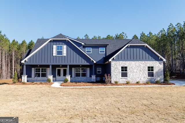 view of front of property with board and batten siding, french doors, roof with shingles, and stone siding