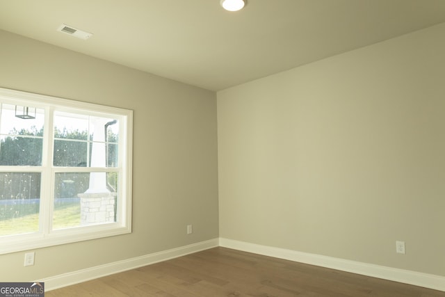 spare room with visible vents, baseboards, and wood finished floors