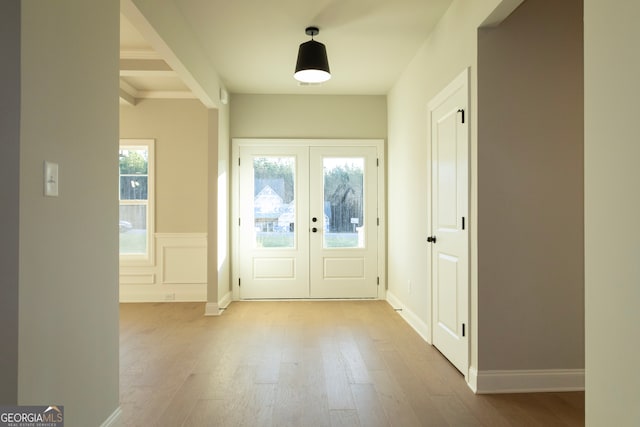 doorway featuring beam ceiling, french doors, and light hardwood / wood-style flooring