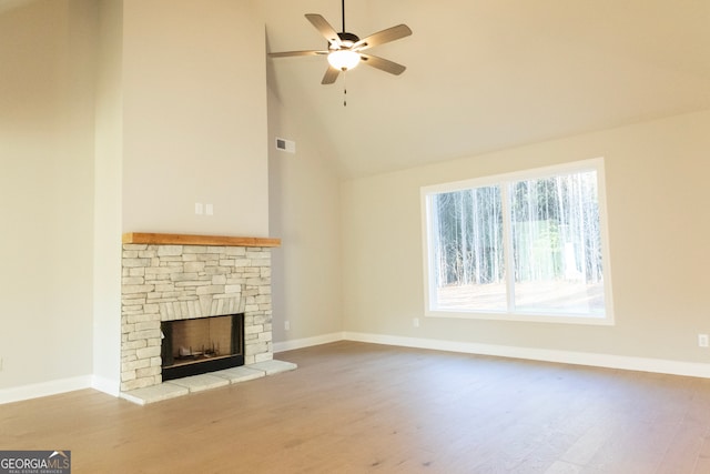 unfurnished living room with a fireplace, light wood-type flooring, high vaulted ceiling, and ceiling fan