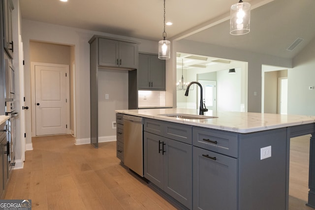 kitchen with light stone counters, sink, pendant lighting, a center island with sink, and dishwasher