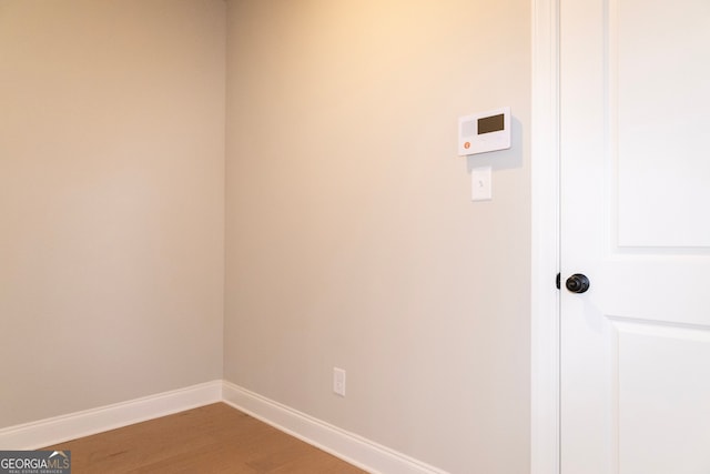 clothes washing area with hardwood / wood-style flooring