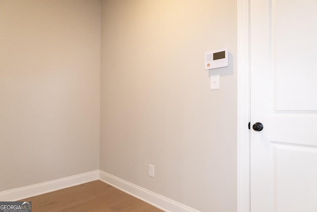 washroom featuring wood finished floors and baseboards