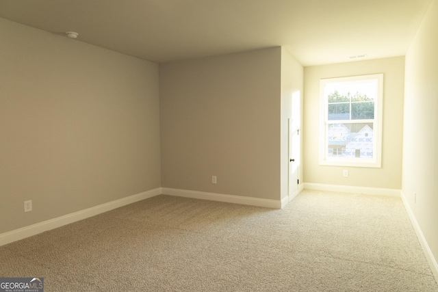 empty room featuring carpet flooring and baseboards