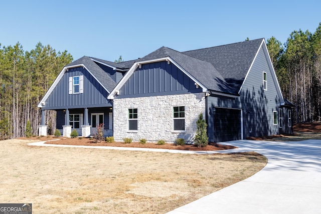 view of front of house featuring board and batten siding, covered porch, driveway, and a shingled roof